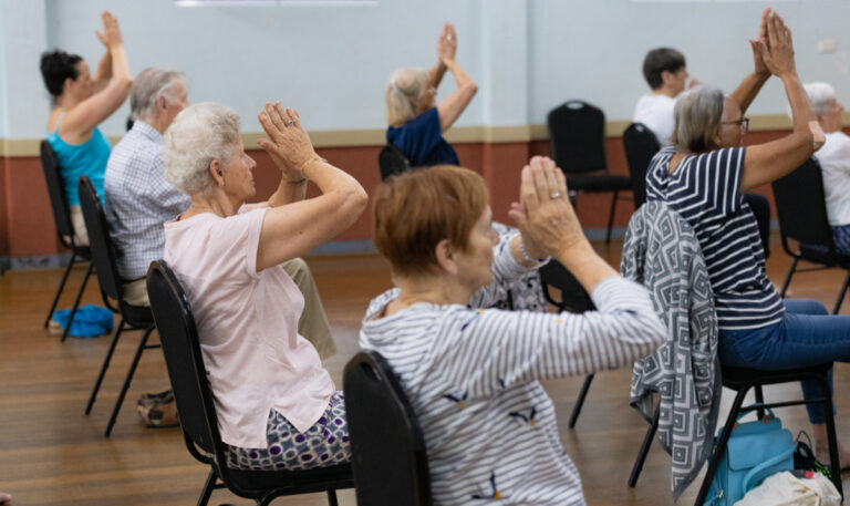 A photo of students practicing safe chair yoga techniques